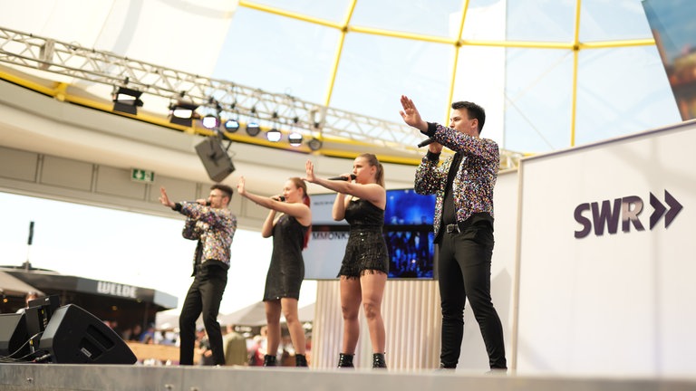 Die Musikgruppe MMONKS gibt auf der Maimarkt-Bühne Musicalhits zum Besten