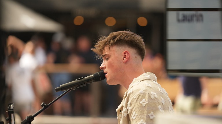 Musiker Laurin singt gefühlvoll in sein Mikro.