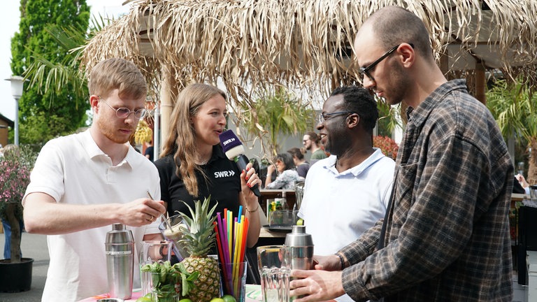 Drei SWR-Volontär*innen auf dem Maimarkt bei einer Cocktail-Challenge 