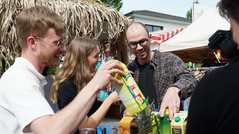 Drei SWR-Volontär*innen auf dem Maimarkt bei einer Cocktail-Challenge 