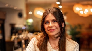 Eine Frau mit langen braunen Haare in einer Bar