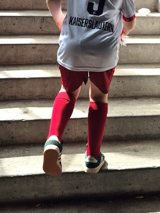 Junger Fan des 1. FC Kaiserslautern läuft Stufen empor. 