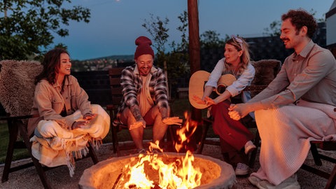 Gemeinsam am Feuer in der Nacht gegen die Einsamkeit