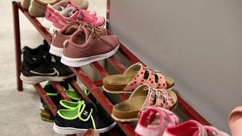 Hausschuhe stehen in einem Schuhregal einer Grundschule