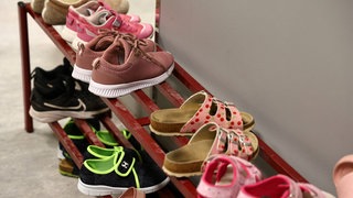Hausschuhe stehen in einem Schuhregal einer Grundschule