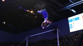 Turner Lukas Dauser bei einem spktakuläen Flugteil am Reck