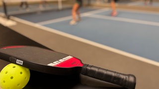 Pickleball Schläger und Ball.