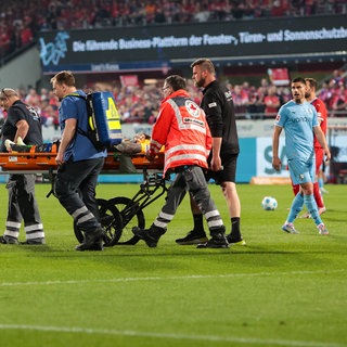 Heidenheims Keeper Kevin Müller wird aus dem Stadion transportiert