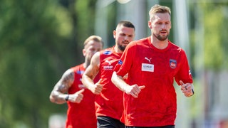 Kapitän Patrick Mainka läuft beim Laktat-Test des 1. FC Heidenheim an der Spitze einer Gruppe aus drei Personen, die sich leicht unschafr im Hintergrund zeigt.