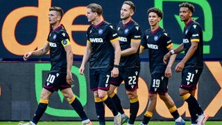 Marvin Wanitzek (Kapitän KSC) mit seinen Mitspielern Dzenis Burnic, Christoph Kobald, Louey Ben Farhat, Bambasé Conté