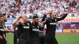 Die VfB Stürmer Demirovic, Undav und Woltemade feiern den Sieg gegen Leipzig. 