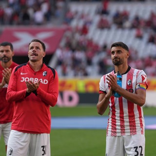 Nach der 1:3-Niederlage gegen den FC Augsburg lassen sich Kapitän Christian Günter und Torschütze Vincenzo Grifo von den Fans des SC Freiburg aufmuntern.
