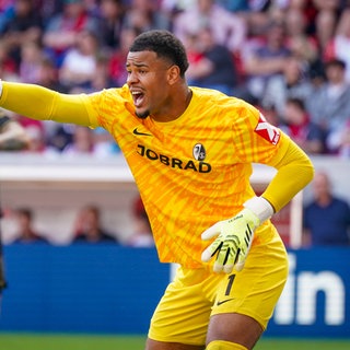 Noah Atubolu mit erhobenem Arm am Pfosten gestikulierend