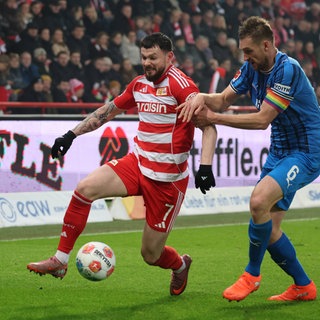 Patrick Mainka vom 1. FC Heidenheim im Zweikampf mit Oliver Burke. 