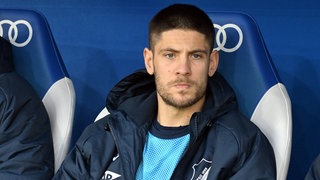Andrej Kramarić sitzt am Spielfeldrand auf der Bank der TSG Hoffenheim. 