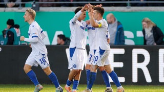 Torschütze Marvin Wanitzek (Karlsruher SC, re.) wird von seinen Mitspielern für den Treffer zum 1:0 in Münster beglückwünscht