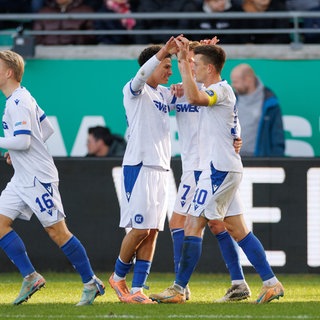 Torschütze Marvin Wanitzek (Karlsruher SC, re.) wird von seinen Mitspielern für den Treffer zum 1:0 in Münster beglückwünscht