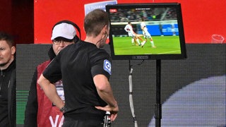 Referee Stegemann schaut sich eine strittige Szene im Spiel zwischen Heidenheim und dem VfB Stuttgart (3:3) an