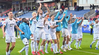 Die Spieler der TSG Hoffenheim feiern vor ihrer Fankurve. Denn nach dem 4:2-Sieg in Heidenheimsind die Kraichgauer klar auf Champions-League-Kurs.
