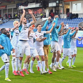 Die Spieler der TSG Hoffenheim feiern vor ihrer Fankurve. Denn nach dem 4:2-Sieg in Heidenheimsind die Kraichgauer klar auf Champions-League-Kurs.