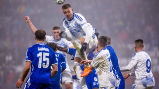 Daniel Vasulin bei einem Kopfball umringt von Gegenspielern. 