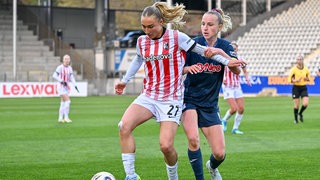 Sophie Nachtigall (SC Freiburg) am Ball und im Duell mit Vanessa Diehm (TSG Hoffenheim).