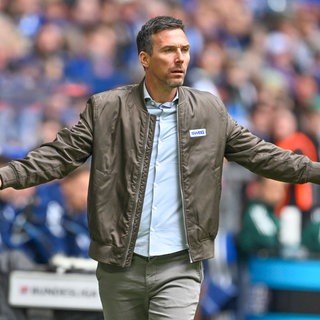 KSC-Trainer Christian Eichner steht gegen den FC Schalke 04 mit weit ausgebreiteten Armen am Spielfeldrand (Aufnahme vom 05.04.2026).