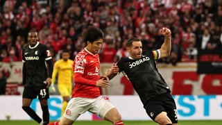 Zweikampf zwischen Christian Gübnter vom SC Freiburg und Sota Kawasaki von Mainz 05 (links)