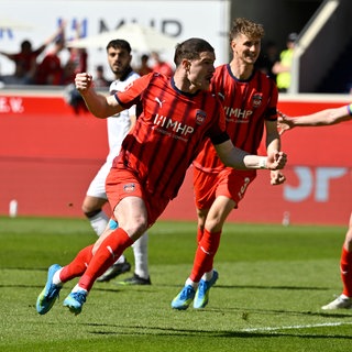 Budu Zivzivadze, Jan Schöppner und Patrick Mainka feiern den Sieg des 1. FC Heidenheim gegen den FC St. Pauli.