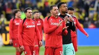 Christian Guenter (SC Freiburg) und Torwart Noah Atubolu (SC Freiburg) applaudieren nach dem Bundesligaspiel zwischen Borussia Dortmund und Club Freiburg.