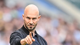 Hoffenheim Trainer Christian Ilzer zeigt mit dem Finger in eine Richtung