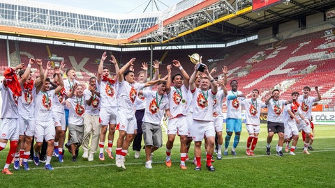 FCK-Kapitän Jean Zimmer präsentiert den Meisterschaftspokal nach dem Aufstieg vor der Westkurve im Fritz-Walter-Stadion