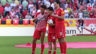 Derry Scherhant, Yuito Suzuki und Igor Matanovic vom SC Freiburg. (Bild mit KI bearbeitet)