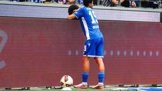 Louey Ben Farhat vom KSC lehnt über einer Werbebande