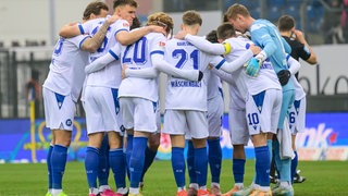 Spieler des Karlsruher SC bilden einen Kreis.