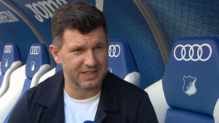 Andreas Schicker im Interview auf der Trainerbank im Hoffenheimer Stadion.
