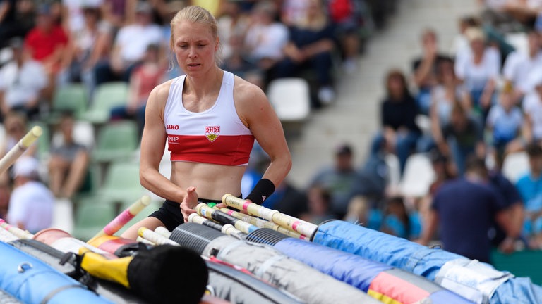 Anjuli Knäsche sucht vor einer großen Menge Stäbe ihren eigenen