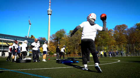 Zwei Footballspieler werfen sich einen Football hin un her 