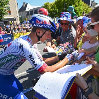 Radfahrer Florian Lipowitz gibt bei der Tour de France Autogramme.