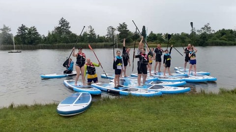 Kinder auf einem XXl-Board auf deinem Fluss bei Bad Dürkheim.