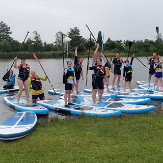 Kinder auf einem XXl-Board auf deinem Fluss bei Bad Dürkheim.