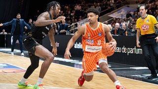 Der Ulmer Aufbauspieler Mark Smith im orangefarbenen Trikot gegen den Braunschweiger Jushua Hawley.