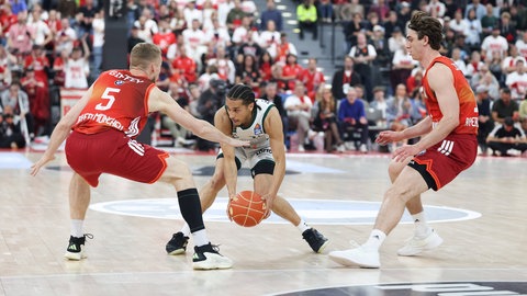 Triers Topscorer Jordan Roland im Duell mit Münchens Niels Giffey und Justinian Jessup