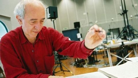 Mann beschreibt Notenpapier