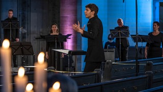Yuval Weinberg dirigiert das SWR Vokalensemble in einer Kirche