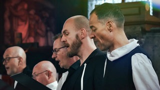 Männer des SWR Vokalensembles singen in einer Kirche