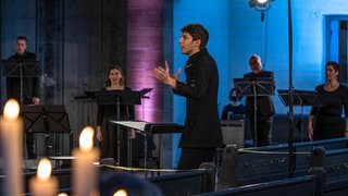 Yuval Weinberg dirigiert das SWR Vokalensemble in einer Kirche