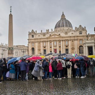 Gläubige warten im Regen in einer Schlange, um dem aufgebahrten Papst Franziskus im Petersdom die letzte Ehre zu erweisen