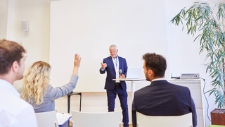 Redner gibt Präsentation bei Business Konferenz vor Publikum im Konferenzraum