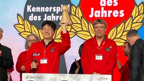 Der weltweit begehrte Pöppel für das "Spiel des Jahres" geht dieses Jahr an den Japaner Hisashi Hayashi (links) und das Spiel "Bomb Busters".